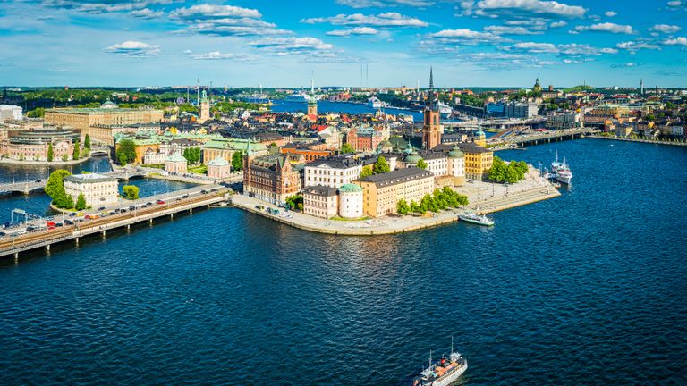 Vista aérea panorámica sobre el cielo azul del verano sobre la icónica costa de Gamla Stan y Södermalm en el corazón de Estocolmo, la bulliciosa capital de Suecia.