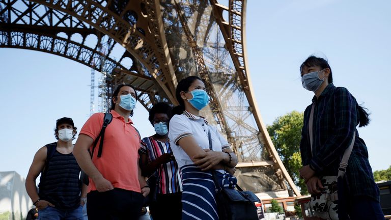 Los visitantes con máscaras faciales hacen cola mientras esperan la apertura parcial de la Torre Eiffel el 25 de junio de 2020 en París, mientras Francia relaja las medidas de bloqueo tomadas para limitar la propagación de COVID-19 causada por el nuevo coronavirus.  