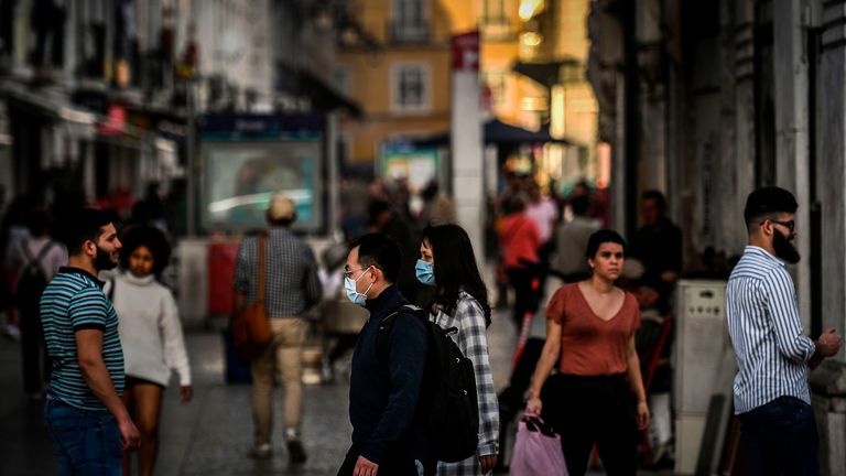 Algunos turistas con máscaras protectoras mientras caminan por Lisboa, Portugal.