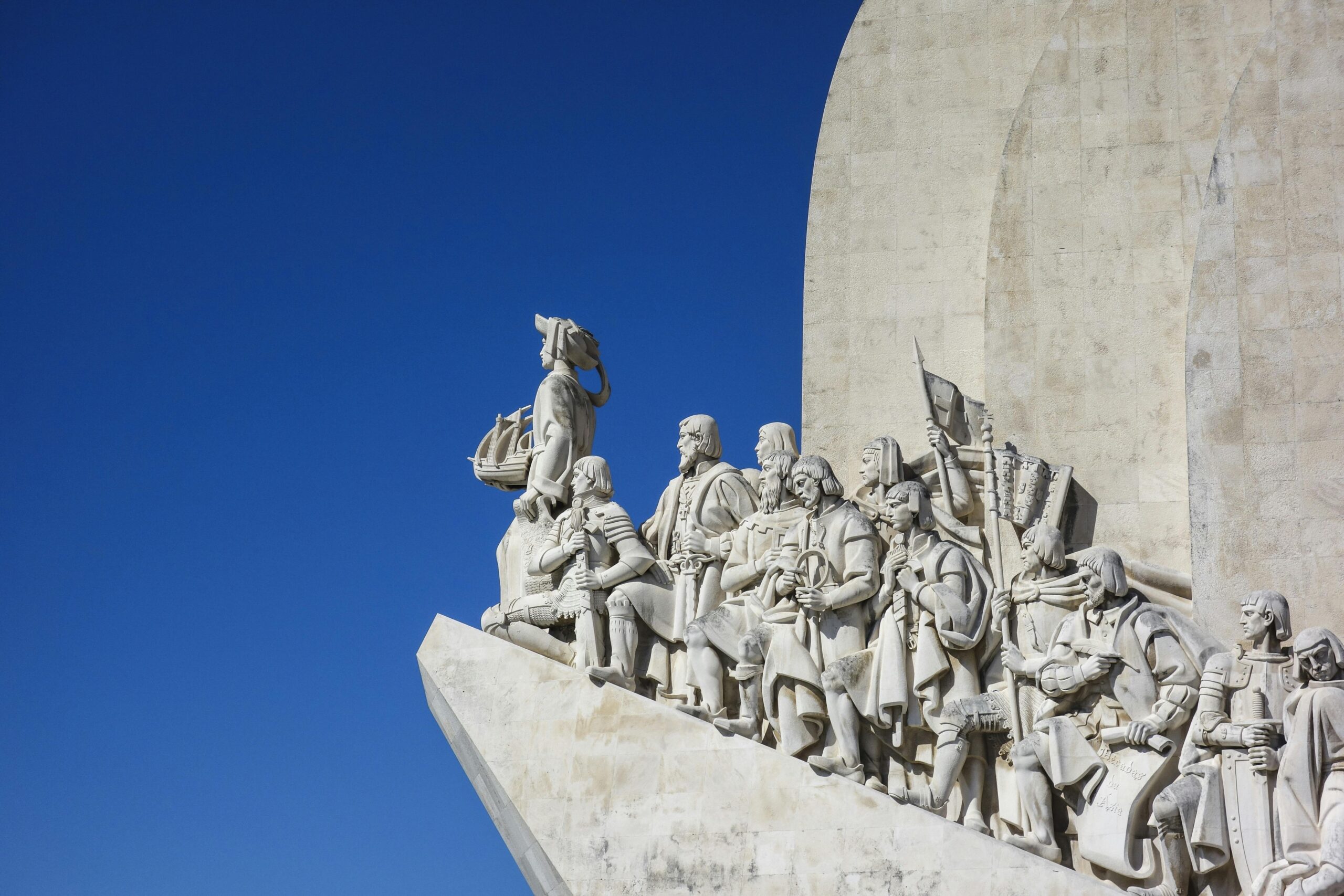 White marble statues of explorers at Lisbon's iconic Monument of Discoveries, Portugal.