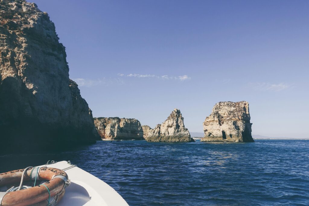 Tranquil scene of Algarve cliffs and ocean from a boat, ideal for travel and vacation themes.