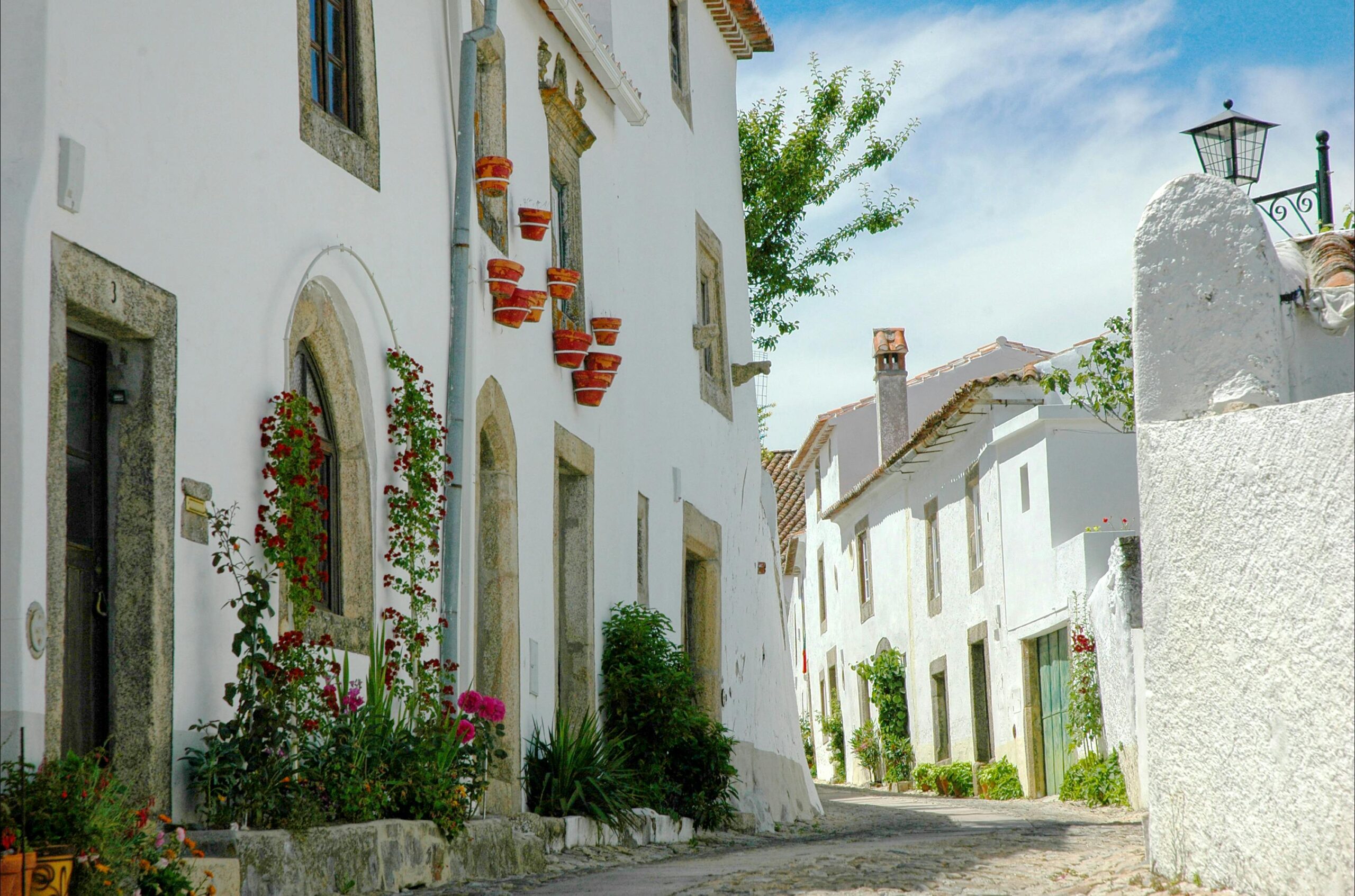 Explore the scenic whitewashed architecture of Marvão, Portugal, showcasing traditional cobblestone streets and historic charm.