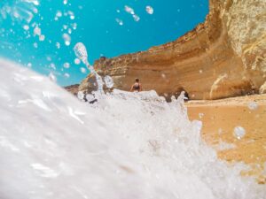 Dynamic view of waves crashing on cliffs at a beach in Lagos, Portugal. Perfect for summer and travel themes.