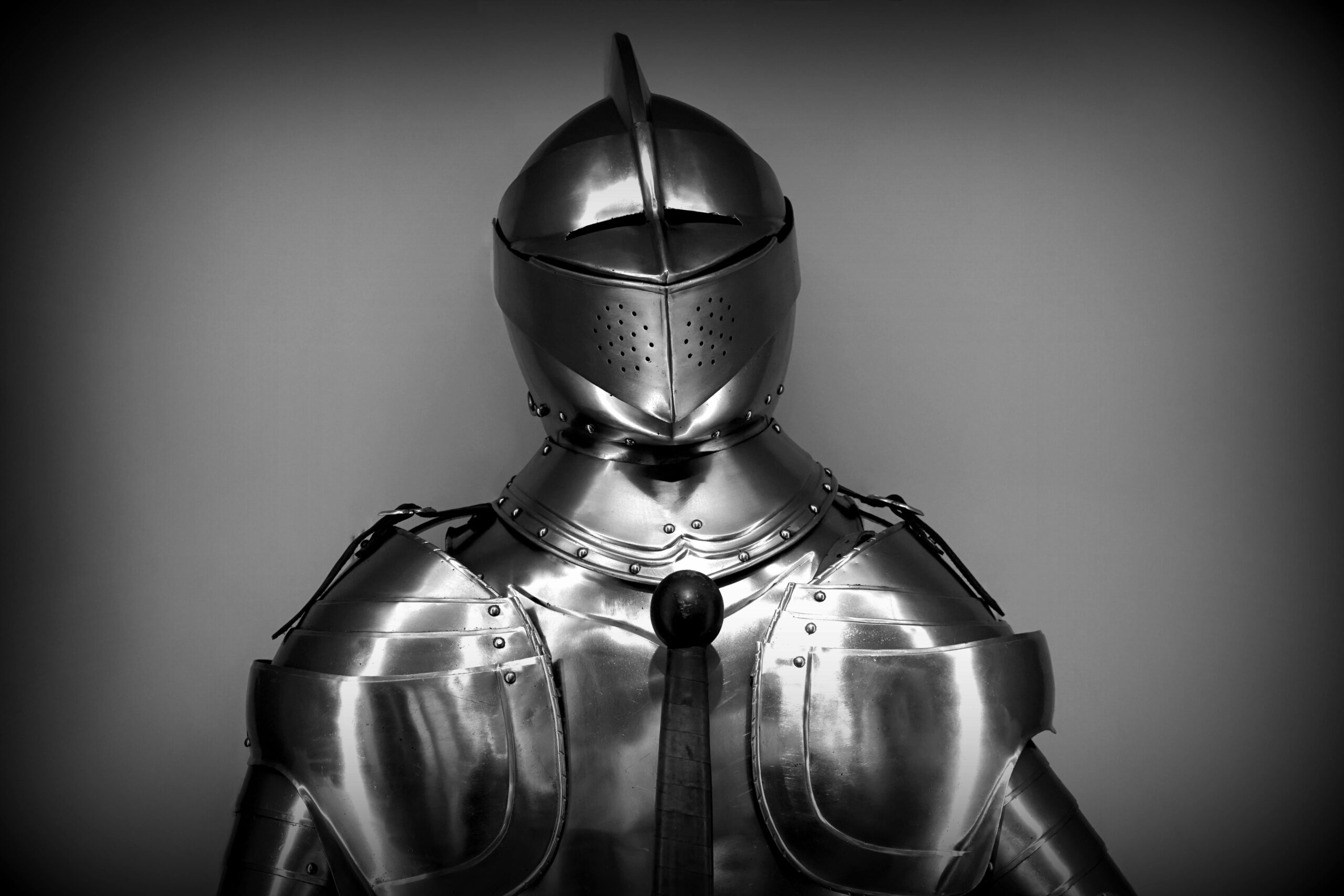 Close-up shot of vintage medieval knight armor in monochrome.