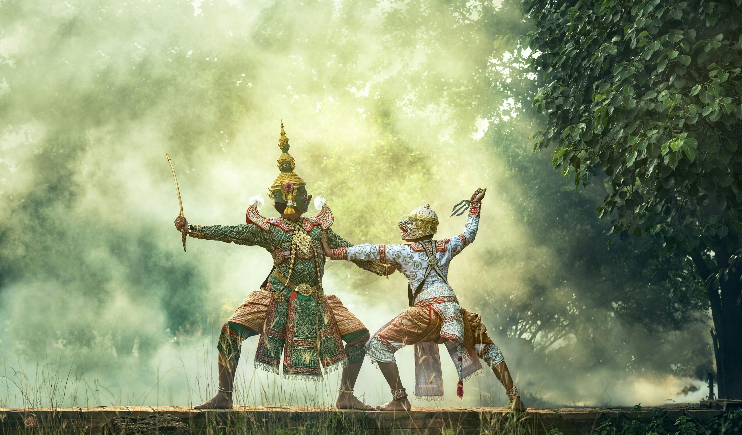 Cultural Asian performance featuring two dancers in elaborate costumes in a misty, outdoor setting.