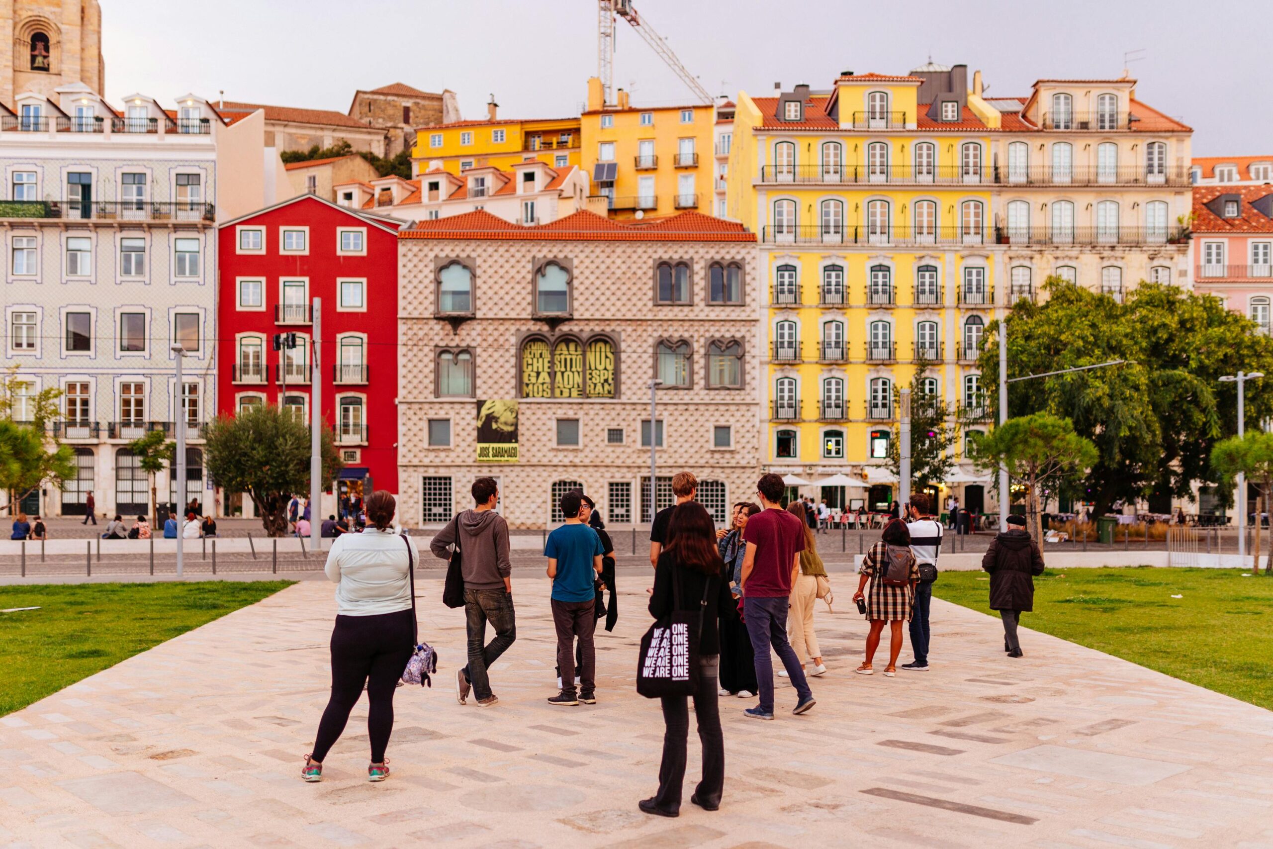 Vibrant Lisbon street scene featuring colorful buildings and a diverse group of tourists.