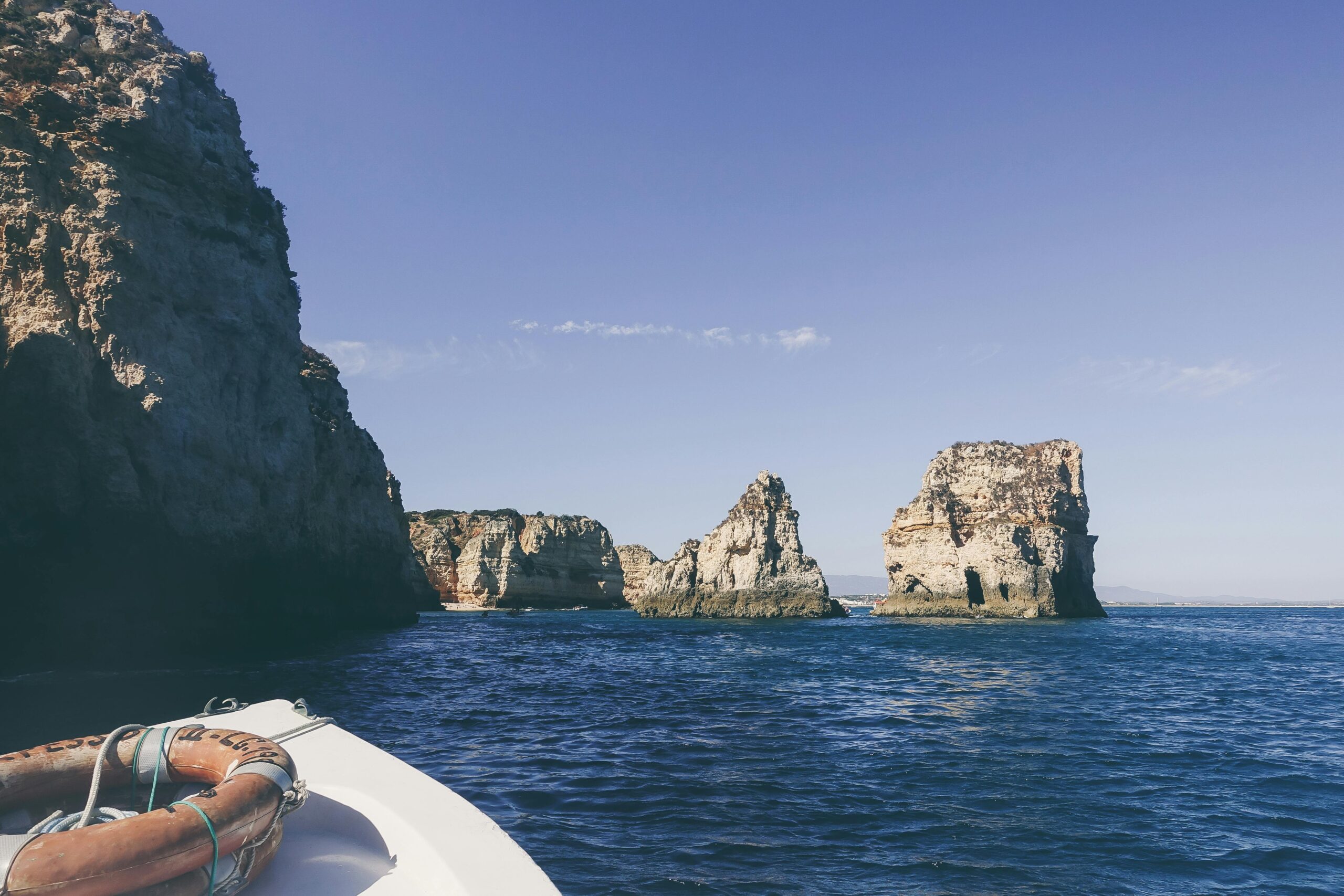 Tranquil scene of Algarve cliffs and ocean from a boat, ideal for travel and vacation themes.