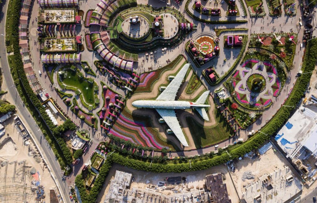 Colorful aerial shot of Dubai Miracle Garden showcasing airplane made of flowers.