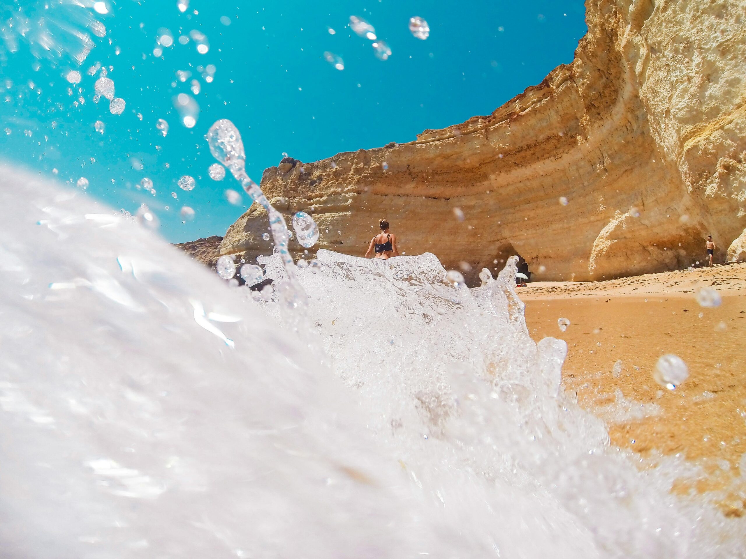 Dynamic view of waves crashing on cliffs at a beach in Lagos, Portugal. Perfect for summer and travel themes.